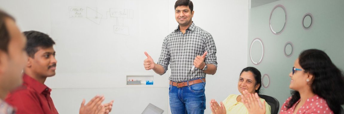 Five employees celebrate a success during a meeting