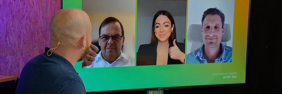 Guy is talking to a group of people via video call. They are giving him a thumbs up.