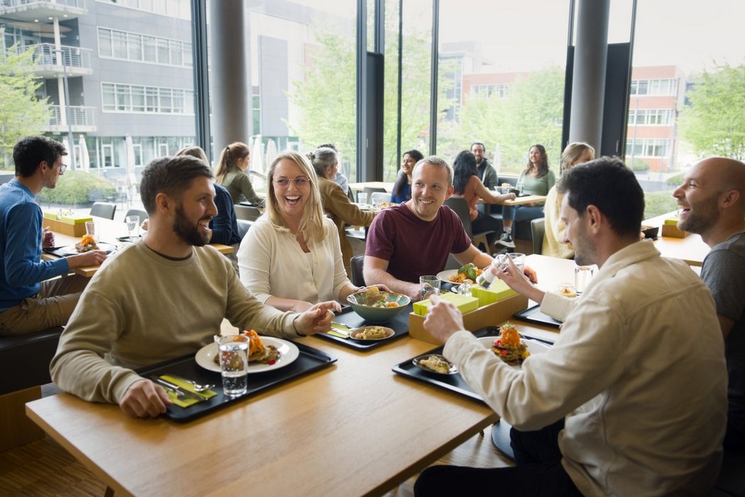 A group of Vector employees sit at a table and eat a delicious lunch.