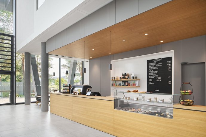 Freundliche Barista Bar mit heller Holztheke und leckeren Süßspeisen und Obst.