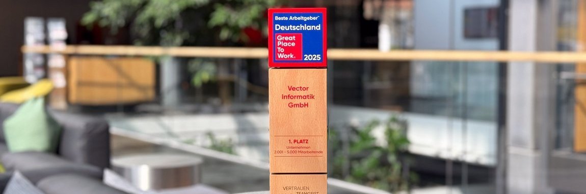 Modern office environment with comfortable seating and a green plant in the background. In the foreground is a wooden award with the title "Best Employer Germany - Great Place to Work 2025".