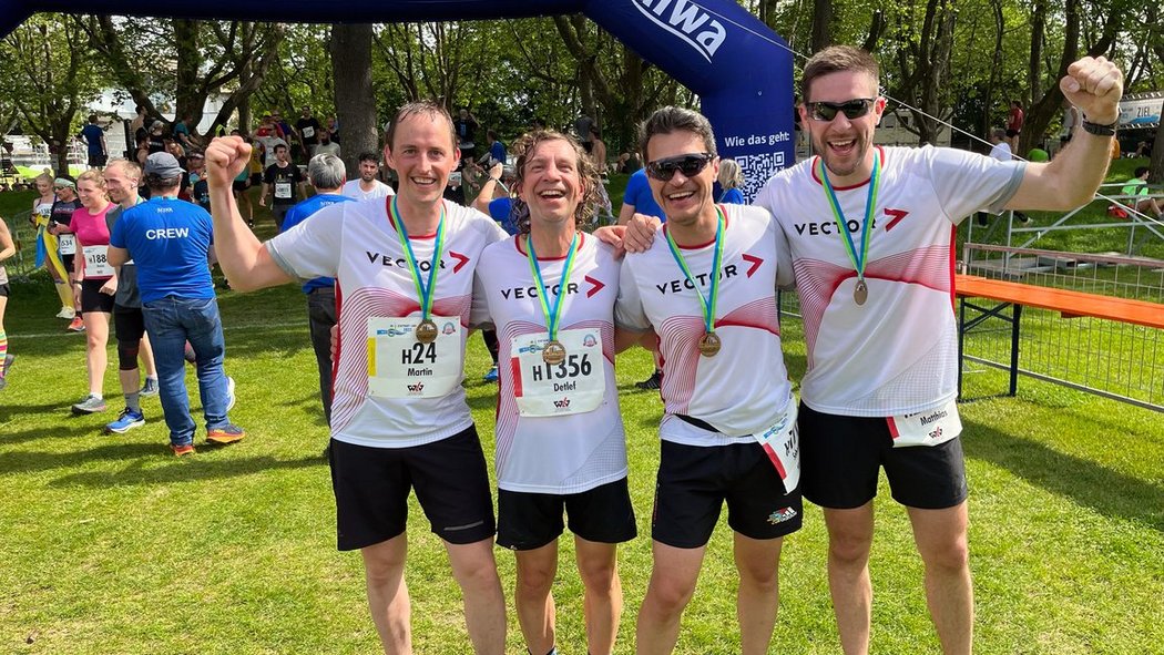 4 Vecorianer mit Finisher-Medaille in Jubelpose.