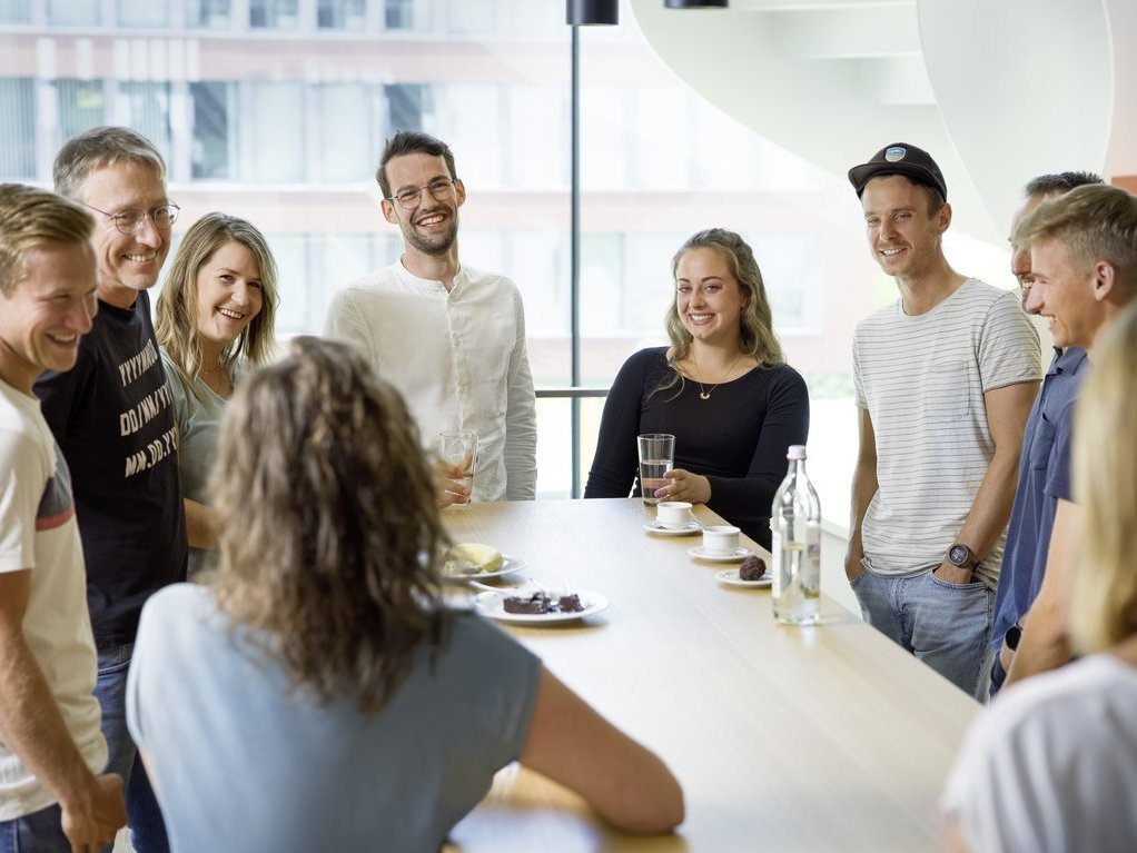 Vector employees in a modern office talking around a table 