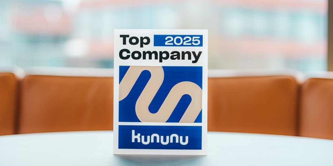 Trophäe "kununu Top Company 2025" auf einem Tisch, im Hintergrund ein Bürogebäude von Vector.