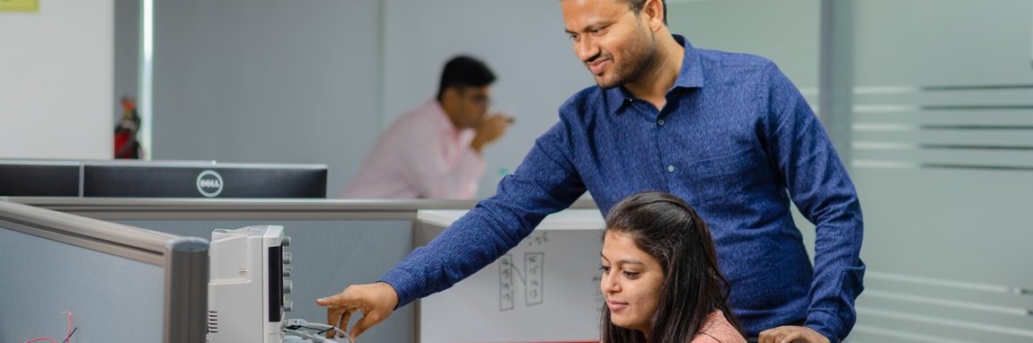 Employee explains a piece of hardware to a colleague