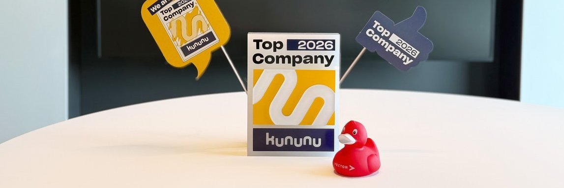kununu trophy for the Top Company 2026 award with a red rubber duck in the foreground and festive pennants in the background.