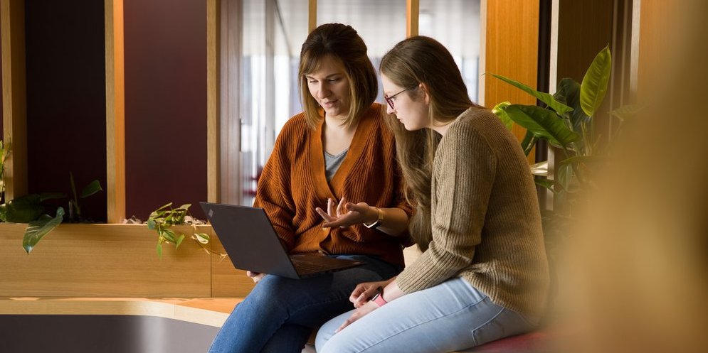 Two Vector employees look intently at the monitor of a notebook