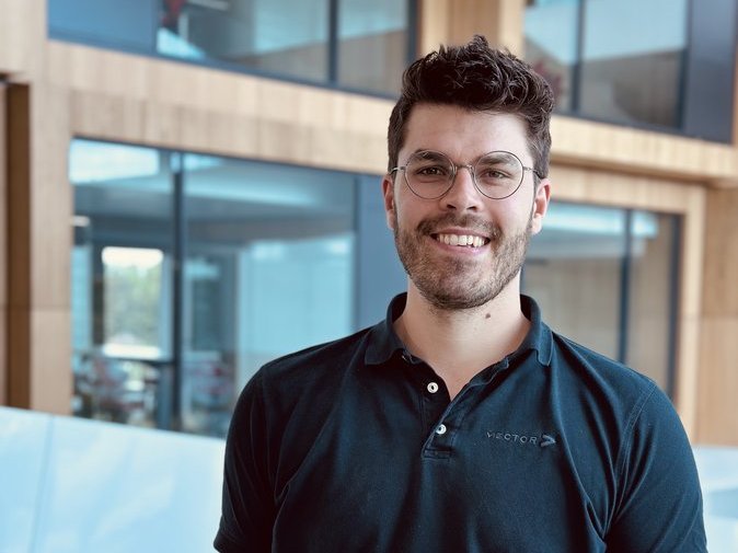 Vector-Kollege in einem modernen Bürogebäude mit Holz und großen Fenstern.