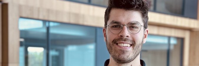 Vector-Kollege in einem modernen Bürogebäude mit Holz und großen Fenstern.