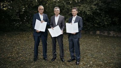 Die drei stolzen Gründer mit einer Urkunde in der Hand.