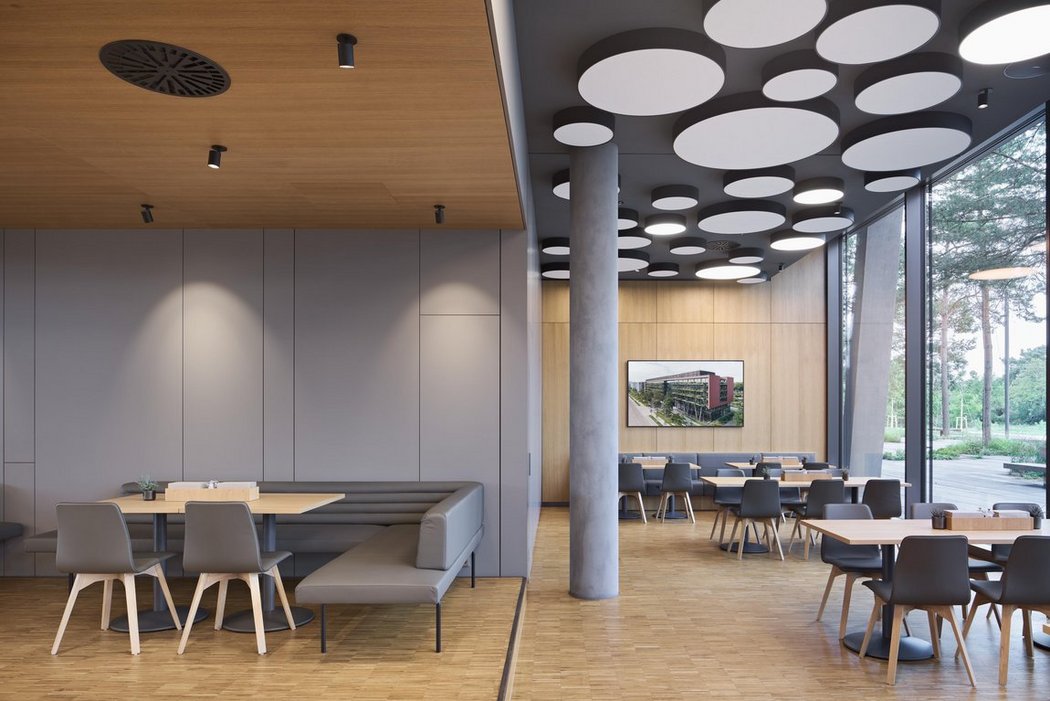 Helle Kantine mit viel Holz und schönen Sitzgelegenheiten.