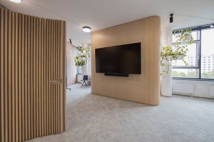 Room with two wooden walls, with a TV hanging on one wall
